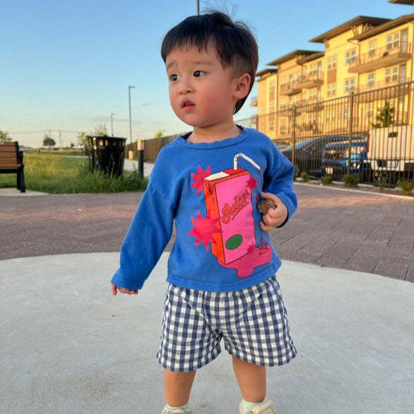 Child wearing a blue sweatshirt with a colorful design outdoors